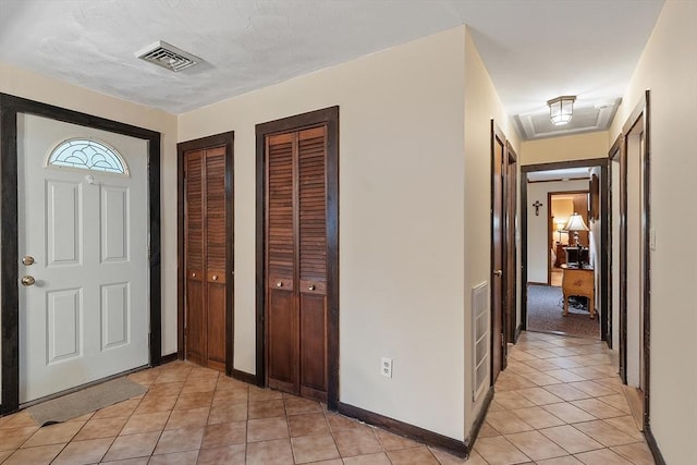 entrance foyer with light tile patterned flooring and baseboards