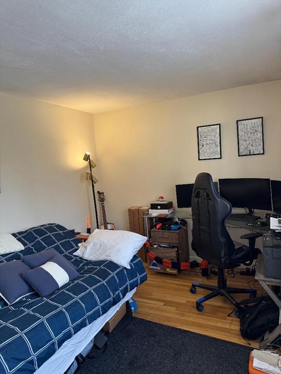 bedroom featuring a textured ceiling and wood finished floors