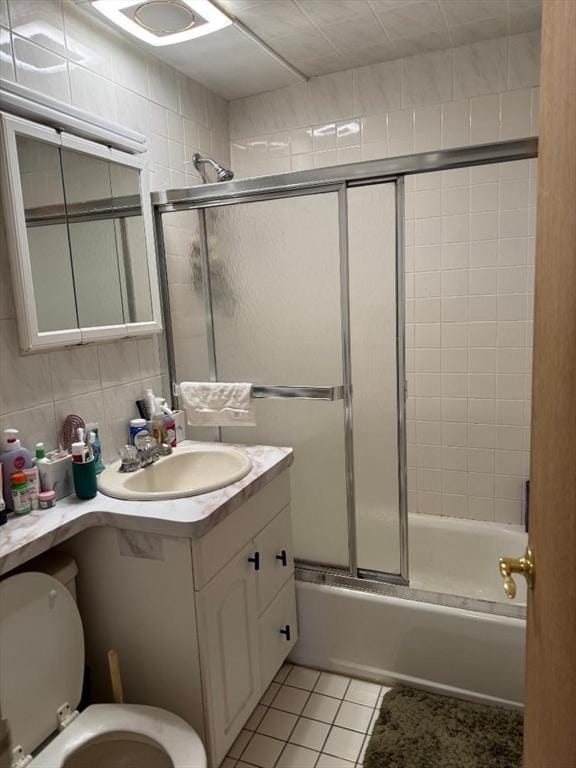 full bath with toilet, tasteful backsplash, combined bath / shower with glass door, tile patterned flooring, and vanity