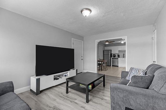 239 Glasgow St Unit 12, Fall River, MA 02721 - living room featuring a textured ceiling, light wood-style flooring, and ceiling fan