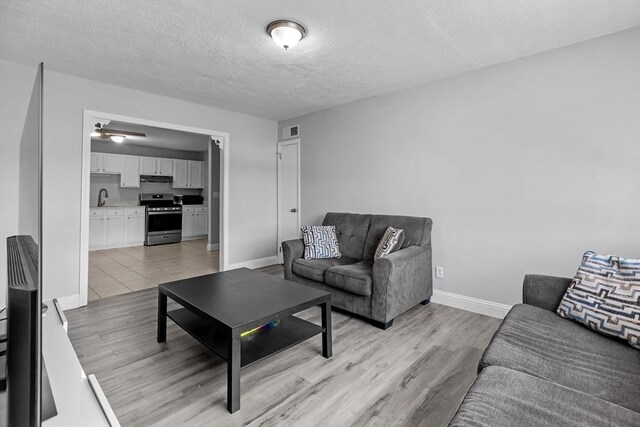 239 Glasgow St Unit 12, Fall River, MA 02721 - living room featuring a textured ceiling and light wood finished floors