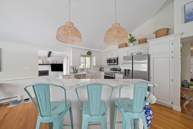 kitchen featuring stainless steel appliances, pendant lighting, white cabinetry, and a peninsula