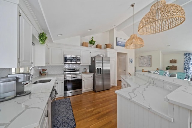 kitchen featuring hanging light fixtures, white cabinetry, stainless steel appliances, and light stone counters