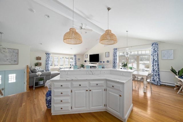 kitchen with white cabinets, open floor plan, hanging light fixtures, and a center island