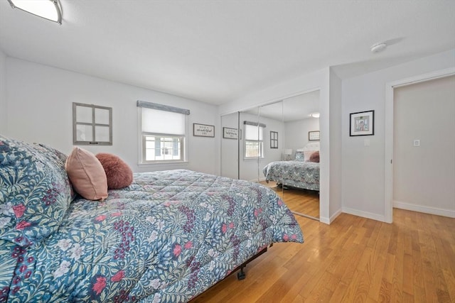 bedroom featuring a closet, baseboards, and light wood finished floors