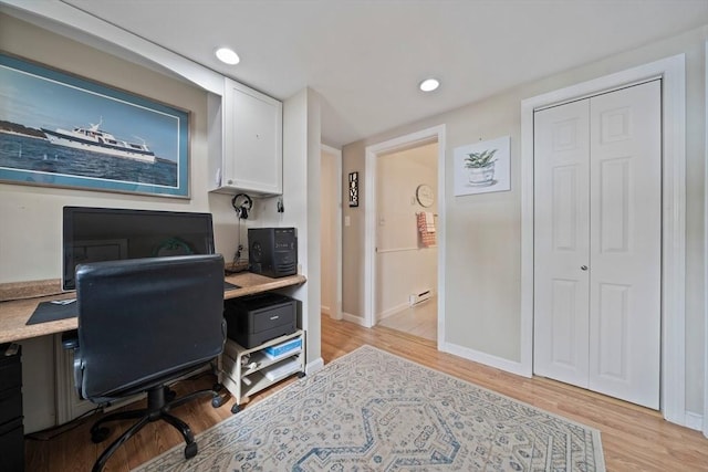 office area with light wood finished floors, recessed lighting, a baseboard radiator, and baseboards