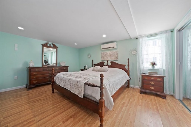 bedroom with recessed lighting, baseboards, a wall mounted air conditioner, and light wood finished floors