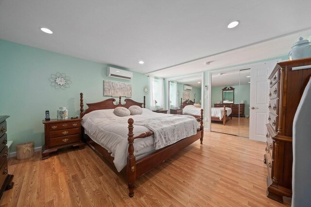 bedroom with a wall mounted AC, recessed lighting, and light wood-style floors