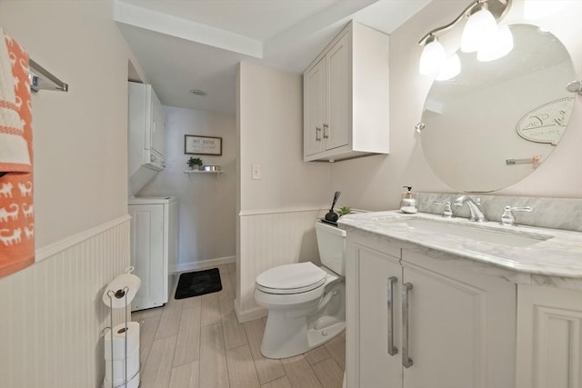 bathroom with toilet, wainscoting, vanity, and wood tiled floor