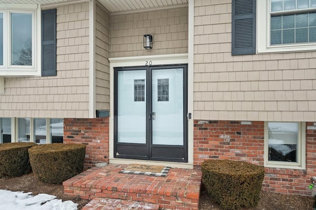 view of exterior entry with french doors and brick siding