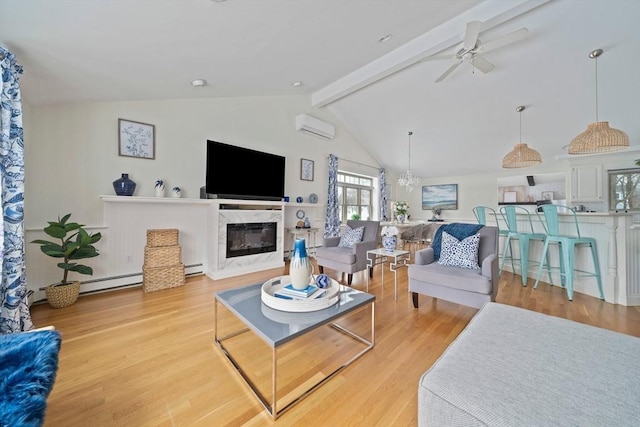 living area with a high end fireplace, lofted ceiling with beams, a wall mounted air conditioner, light wood-type flooring, and ceiling fan with notable chandelier