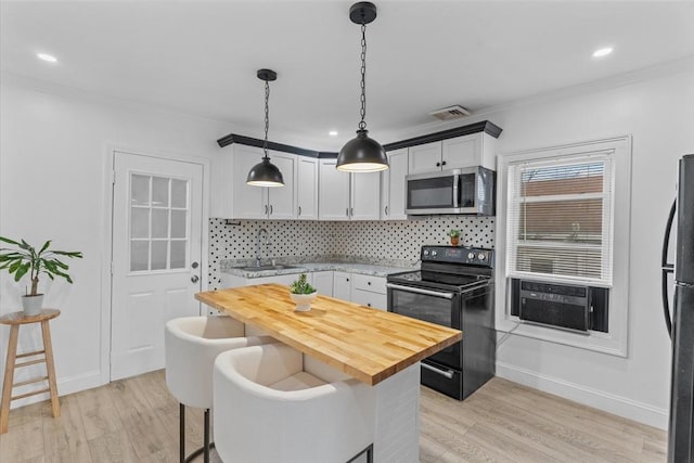 kitchen featuring a kitchen breakfast bar, white cabinetry, pendant lighting, and black range with electric cooktop