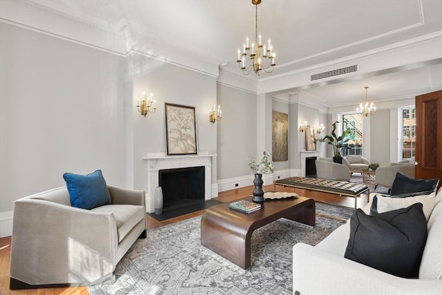 101 Pinckney St, Boston, MA 02114 - living room with an inviting chandelier, ornamental molding, visible vents, wood finished floors, and a premium fireplace