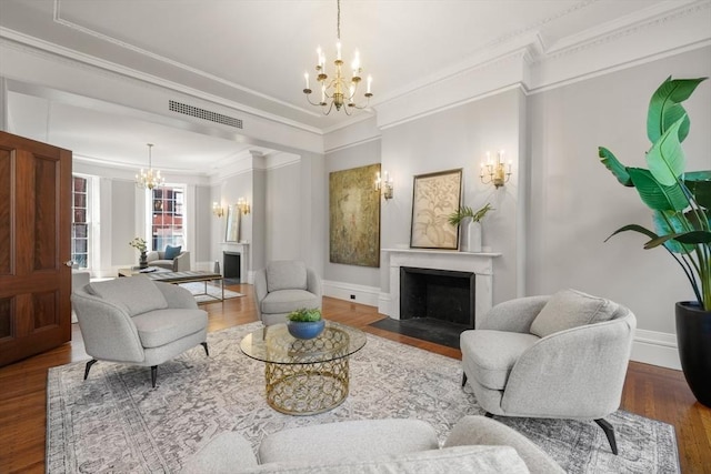 101 Pinckney St, Boston, MA 02114 - living area featuring visible vents, a fireplace with flush hearth, crown molding, wood finished floors, and a chandelier