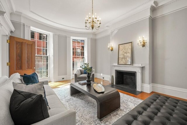 101 Pinckney St, Boston, MA 02114 - living area with crown molding, wood finished floors, a notable chandelier, and a fireplace