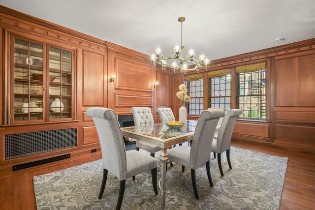 101 Pinckney St, Boston, MA 02114 - dining room with crown molding, wood walls, wood finished floors, and a notable chandelier
