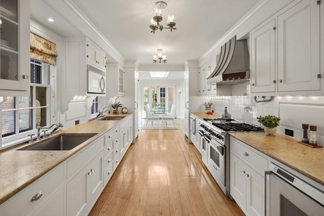 101 Pinckney St, Boston, MA 02114 - kitchen with a sink, beverage cooler, premium range hood, range with two ovens, and white cabinetry