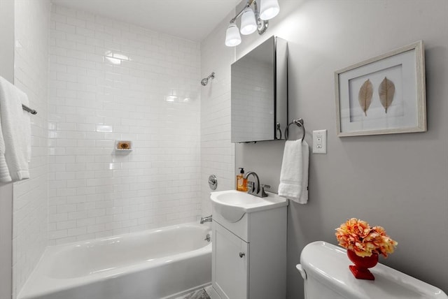 full bathroom featuring vanity, tiled shower / bath, and toilet