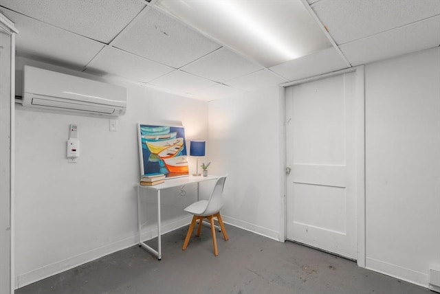 office with concrete floors, a paneled ceiling, and a wall mounted air conditioner