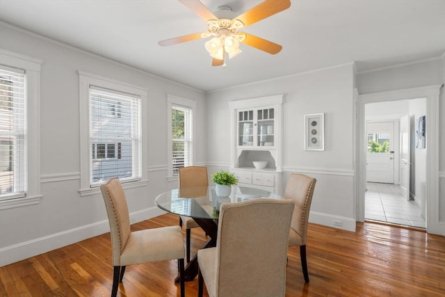 dining space with hardwood / wood-style floors, crown molding, and ceiling fan