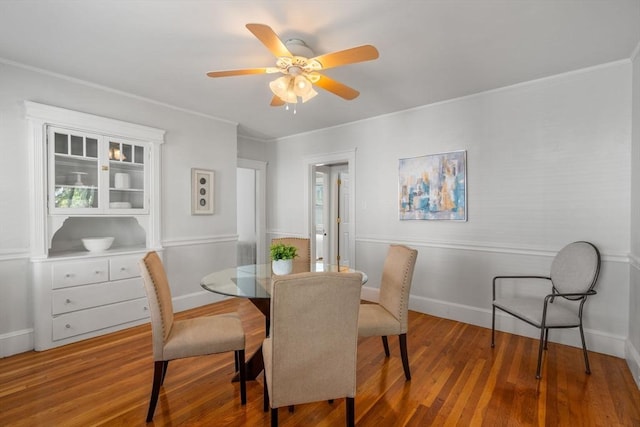 dining room with hardwood / wood-style floors, crown molding, and ceiling fan