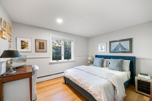 bedroom with wood-type flooring and baseboard heating