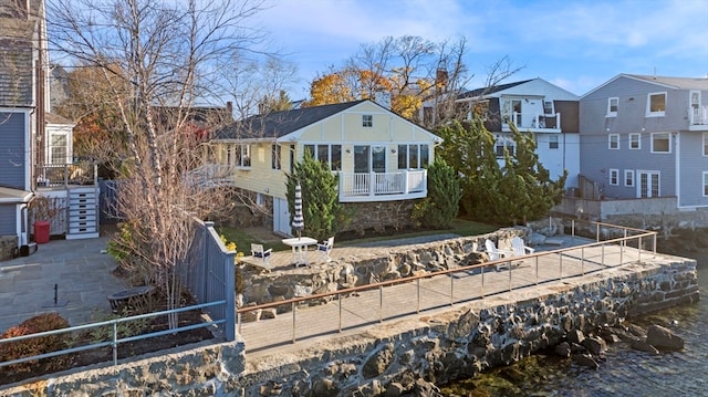 back of house with a water view and a balcony