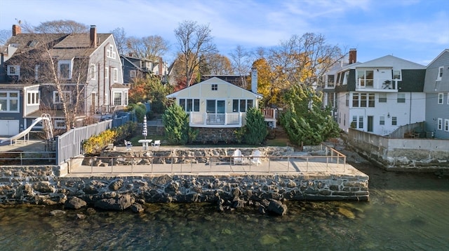 back of property featuring a water view