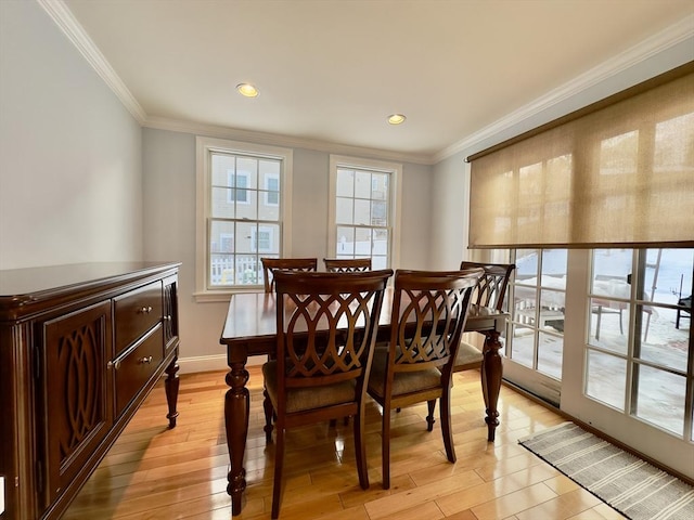 dining space featuring ornamental molding and light wood-type flooring