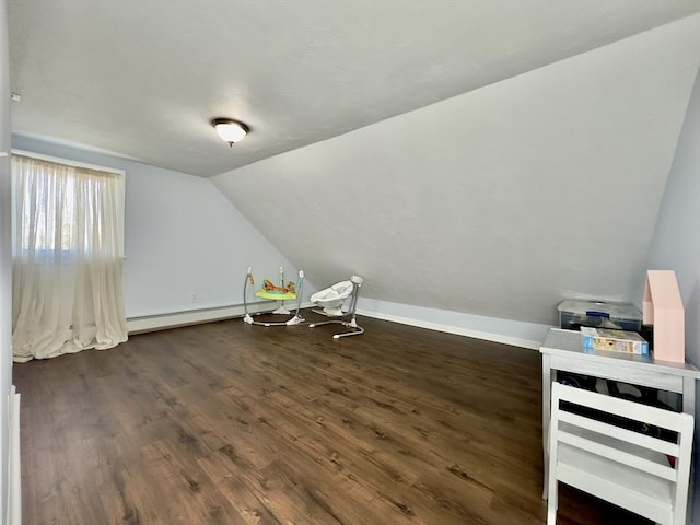 additional living space featuring lofted ceiling, dark wood-type flooring, and baseboard heating