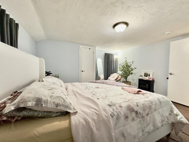 bedroom featuring wood-type flooring and vaulted ceiling