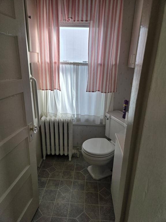 bathroom featuring wallpapered walls, toilet, radiator heating unit, and tile patterned flooring