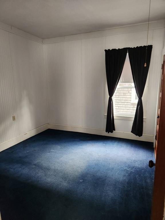 carpeted empty room with baseboards