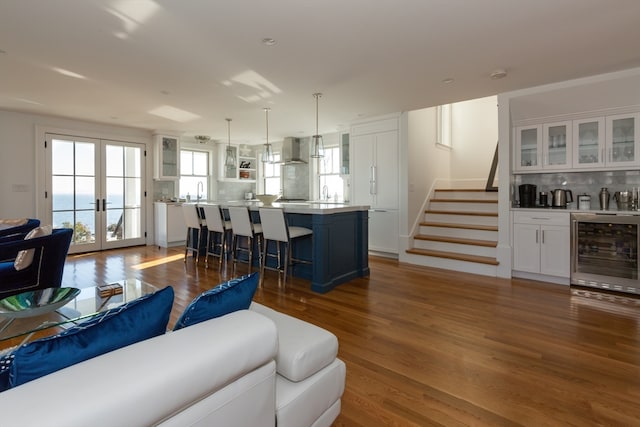 living room with beverage cooler, french doors, and hardwood / wood-style flooring