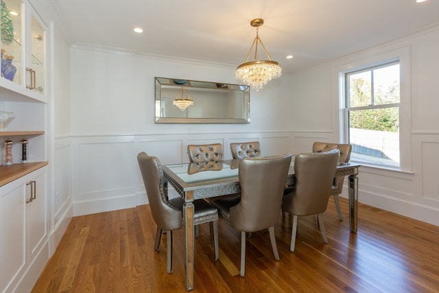 dining room featuring crown molding, hardwood / wood-style flooring, and a chandelier