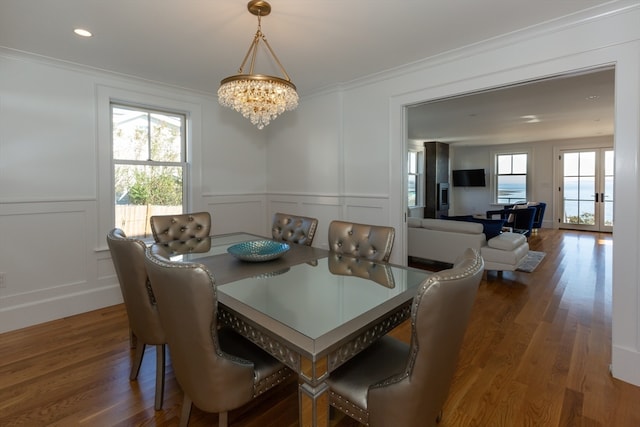 dining room with a chandelier, dark wood-type flooring, and crown molding