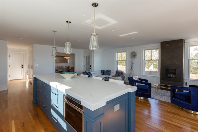 kitchen with dark hardwood / wood-style flooring, a fireplace, a kitchen island, and a wealth of natural light