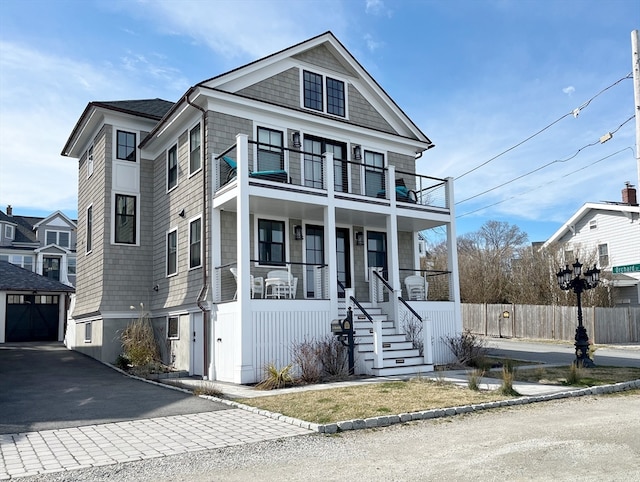 view of front facade featuring a balcony, a porch, and a garage