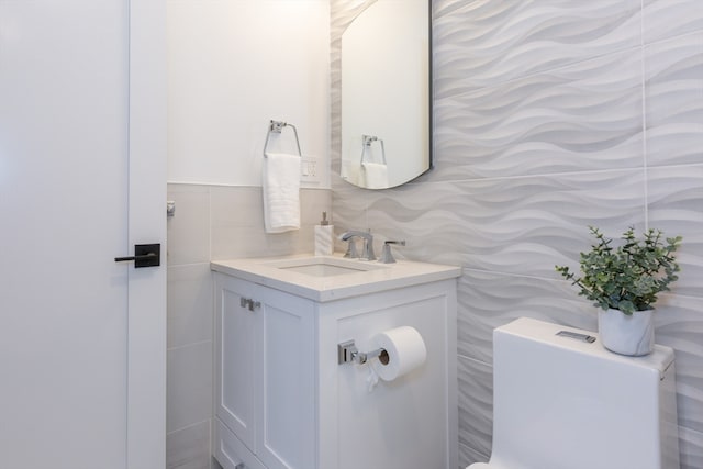 bathroom with tile walls, toilet, and vanity