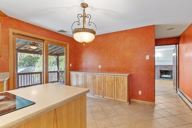 kitchen with visible vents, black electric stovetop, light countertops, a baseboard radiator, and light tile patterned floors