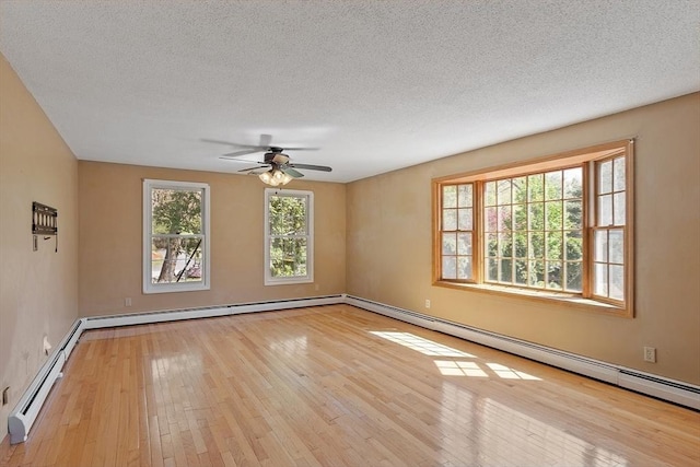 empty room with ceiling fan, a textured ceiling, baseboard heating, a baseboard radiator, and wood-type flooring