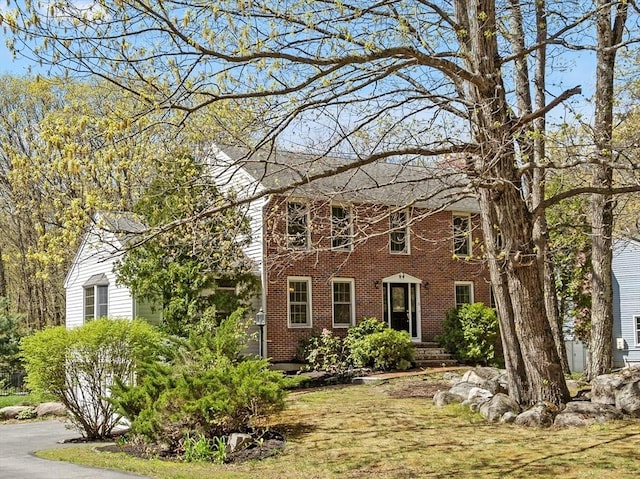 colonial house featuring brick siding