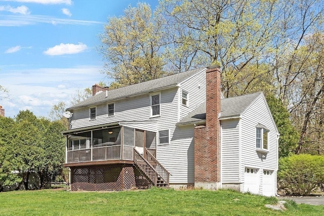 back of house with a garage, a lawn, a chimney, and a sunroom