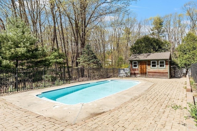 view of swimming pool featuring fence, a fenced in pool, an outbuilding, and a patio