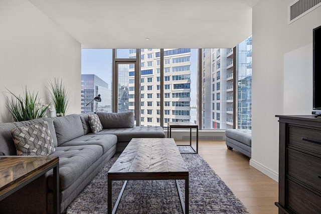 133 Seaport Blvd Unit 1710, Boston, MA 02210 - living room with visible vents, a city view, wood finished floors, and a wall of windows