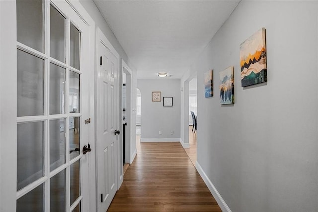 hallway with wood finished floors and baseboards