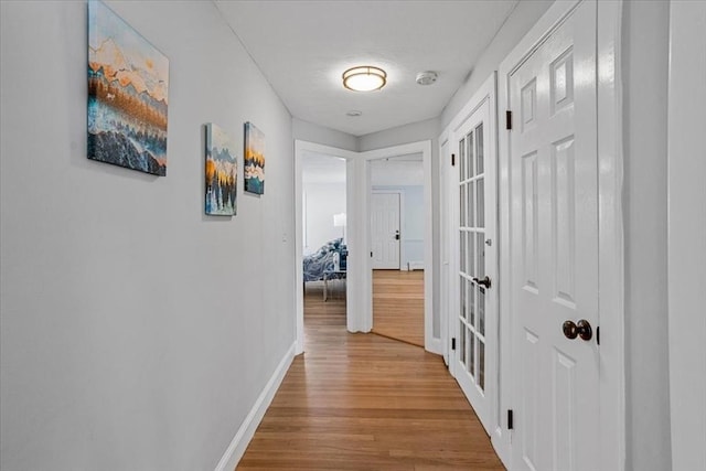 hall featuring baseboards and wood finished floors