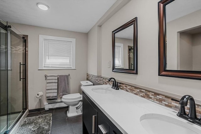 full bathroom featuring a shower stall, baseboard heating, and a sink