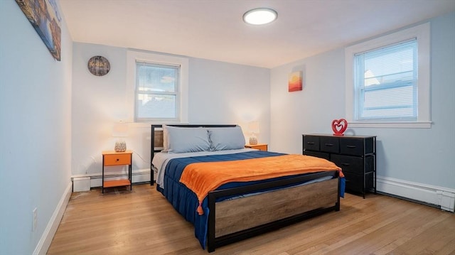 bedroom with light wood-style floors, a baseboard radiator, and baseboards