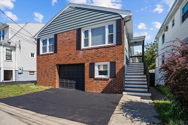 split level home with brick siding, driveway, an attached garage, and stairs